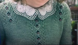 Fitted green cardigan with textured lace panels, worn with neat white, lace collar of blouse