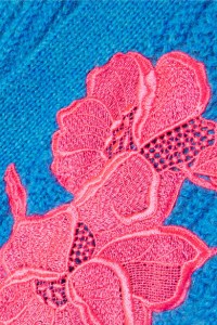 Detail of pink floral applique from Christopher Kane oversized blue cardigan.